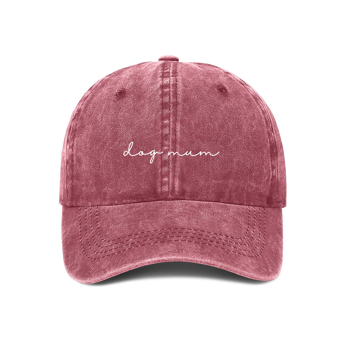 A maroon baseball cap with the text 'dog mum' embroidered on the front, held up against a wall.