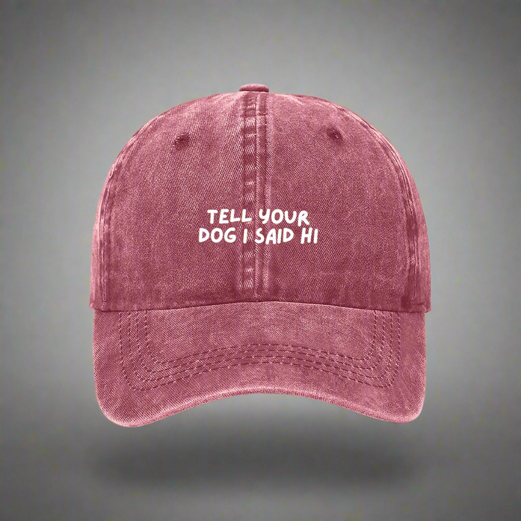 A maroon denim baseball cap with the text 'TELL YOUR DOG I SAID HI' embroidered on the front.