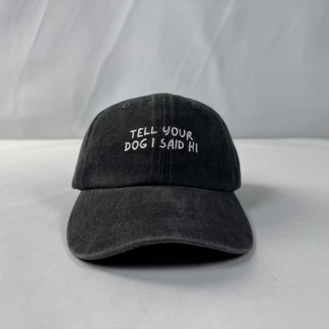Black cap with 'Tell your dog I said hi' text on a white background