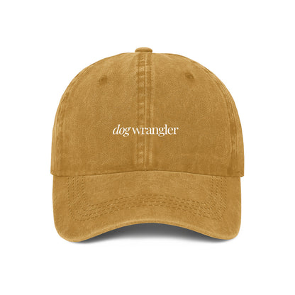 yellow baseball cap with 'dog wrangler' text embroidered on the front.