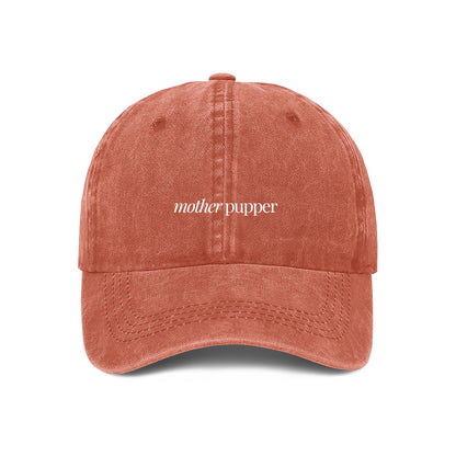orange denim cap with the text 'mother pupper' embroidered on the front, 