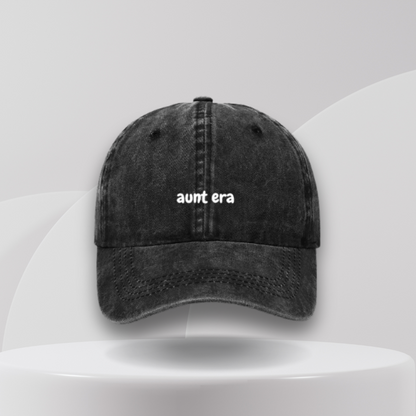 A black denim baseball cap with the text 'aunt era' written on the front.
