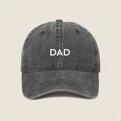 Black cap with 'DAD' embroidered on a white background