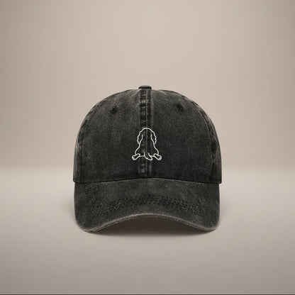 Black cap with a white outline of a dog splooting on a white background