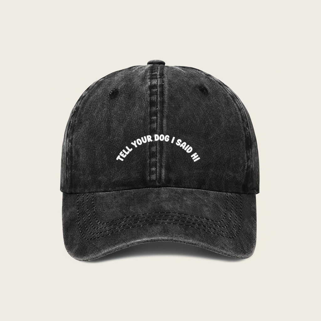 Black cap with white text 'Tell your dog I said hi' on a white background