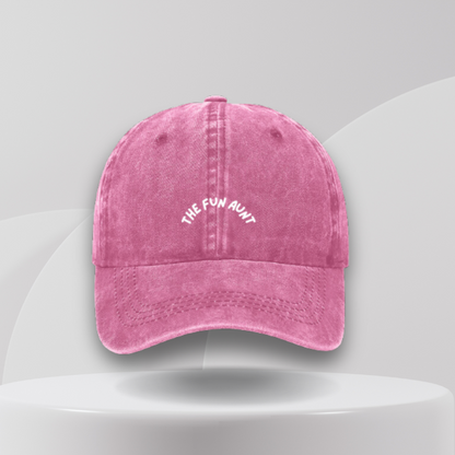 A pink denim baseball cap with the text 'THE FUN AUNT' embroidered on the front.