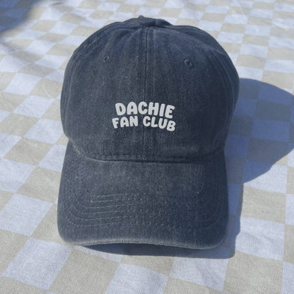 Black cap with 'Dachie Fan Club' text on a checkered floor