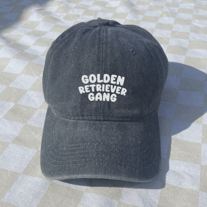 Black cap with 'Golden Retriever Gang' text on a checkered fabric background