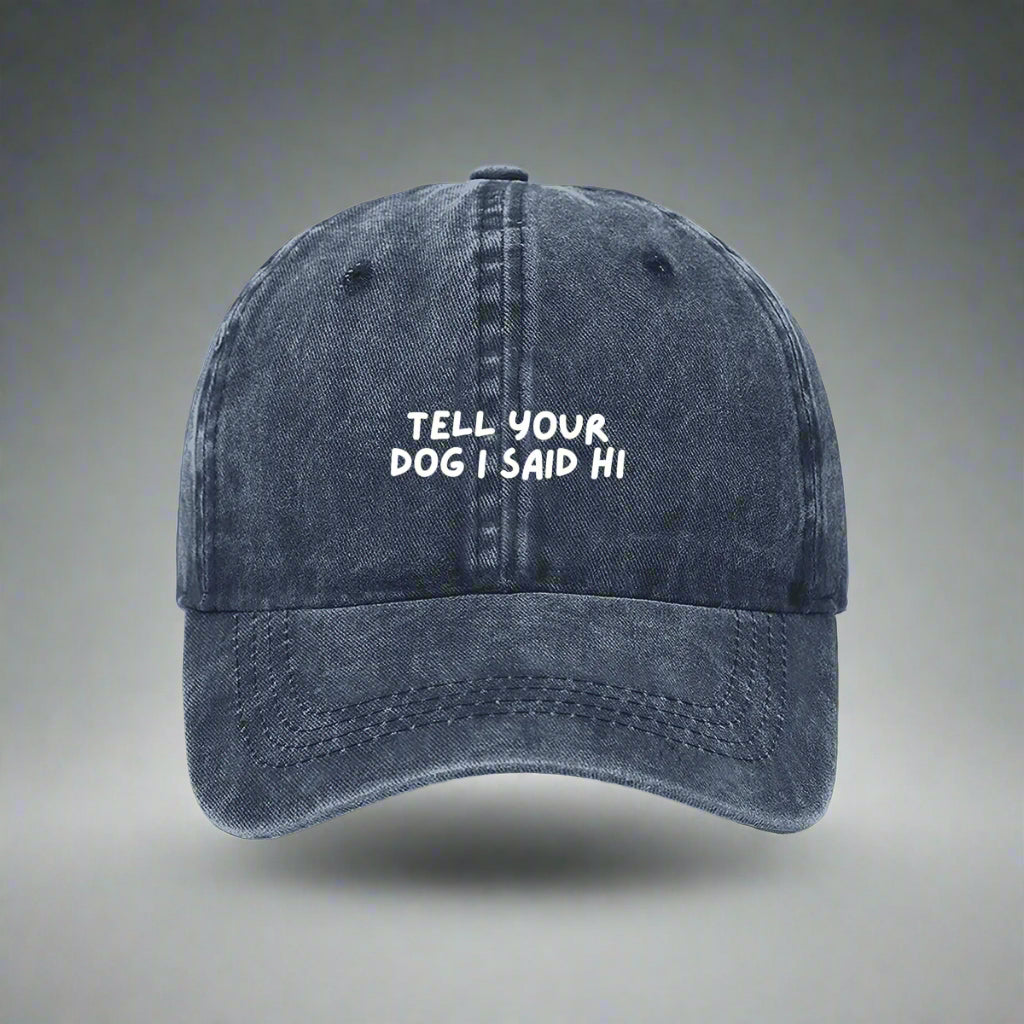 Navy denim baseball cap with the text 'TELL YOUR DOG I SAID HI' embroidered on the front.