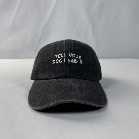 Black cap with 'Tell your dog I said hi' text on a white background
